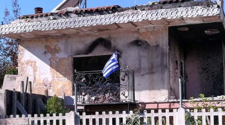 Ύψωσε την ελληνική σημαία στα αποκαΐδια του σπιτιού της στο Μάτι (φωτό)