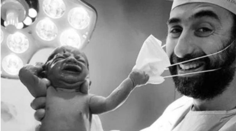 Συγκλονιστική φωτογραφία: Μωράκι τραβάει τη μάσκα μαιευτήρα και γίνεται viral